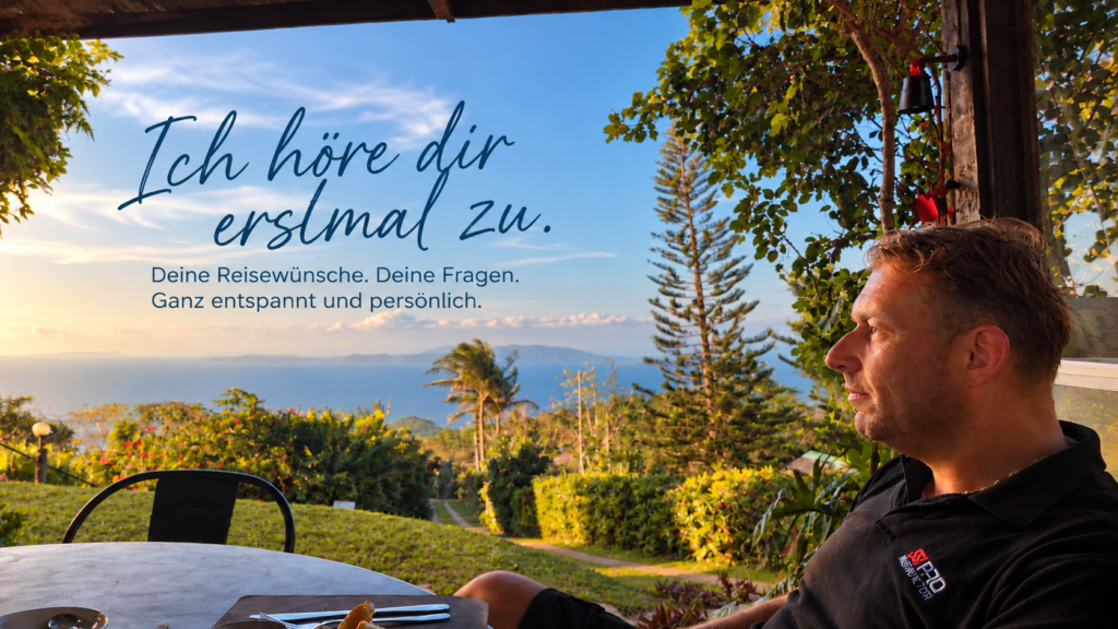 Micha auf einer Terrasse mit Meerblick. Ich höre dir erstmal zu. Deine Reisewünsche. Deine Fragen. Ganz entspannt und persönlich.